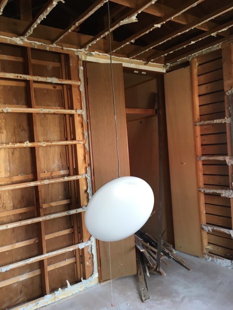 解体工事前に室内に残る建具や残置物を保護しながら撤去準備を進めている様子①