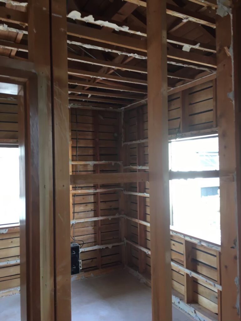 屋内解体が進み、構造材が露出した木造住宅の内部の様子①