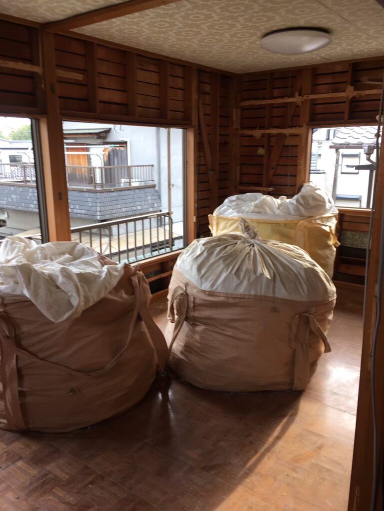 解体工事で発生した石膏ボードや木材をフレコンバッグに分別して保管している屋内の様子①