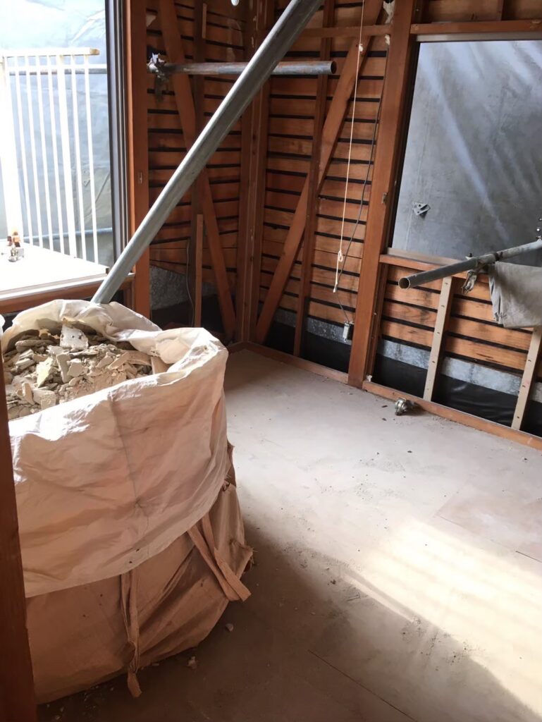 解体工事で発生した石膏ボードや木材をフレコンバッグに分別して保管している屋内の様子②