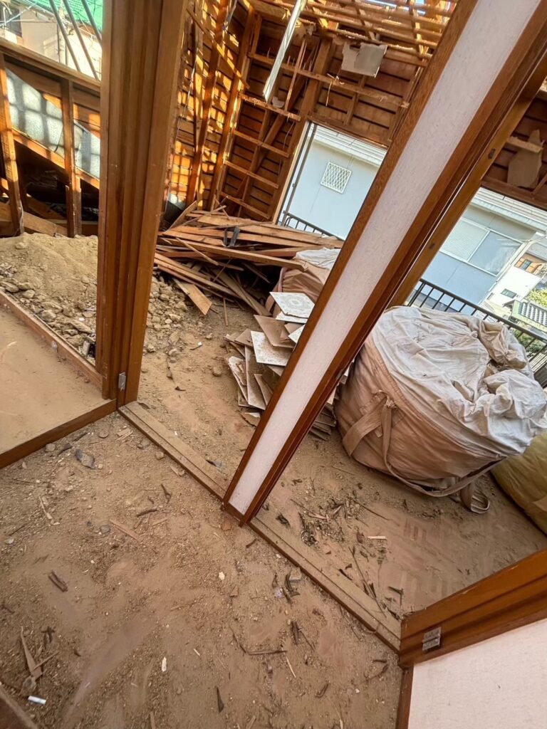 屋根解体が進み、木造住宅の小屋組や梁が露出している状態の様子②