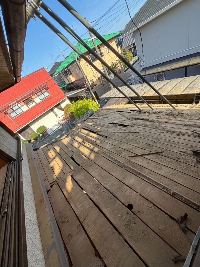 屋根解体が進み、内部構造が見える状態となった木造住宅の外観②